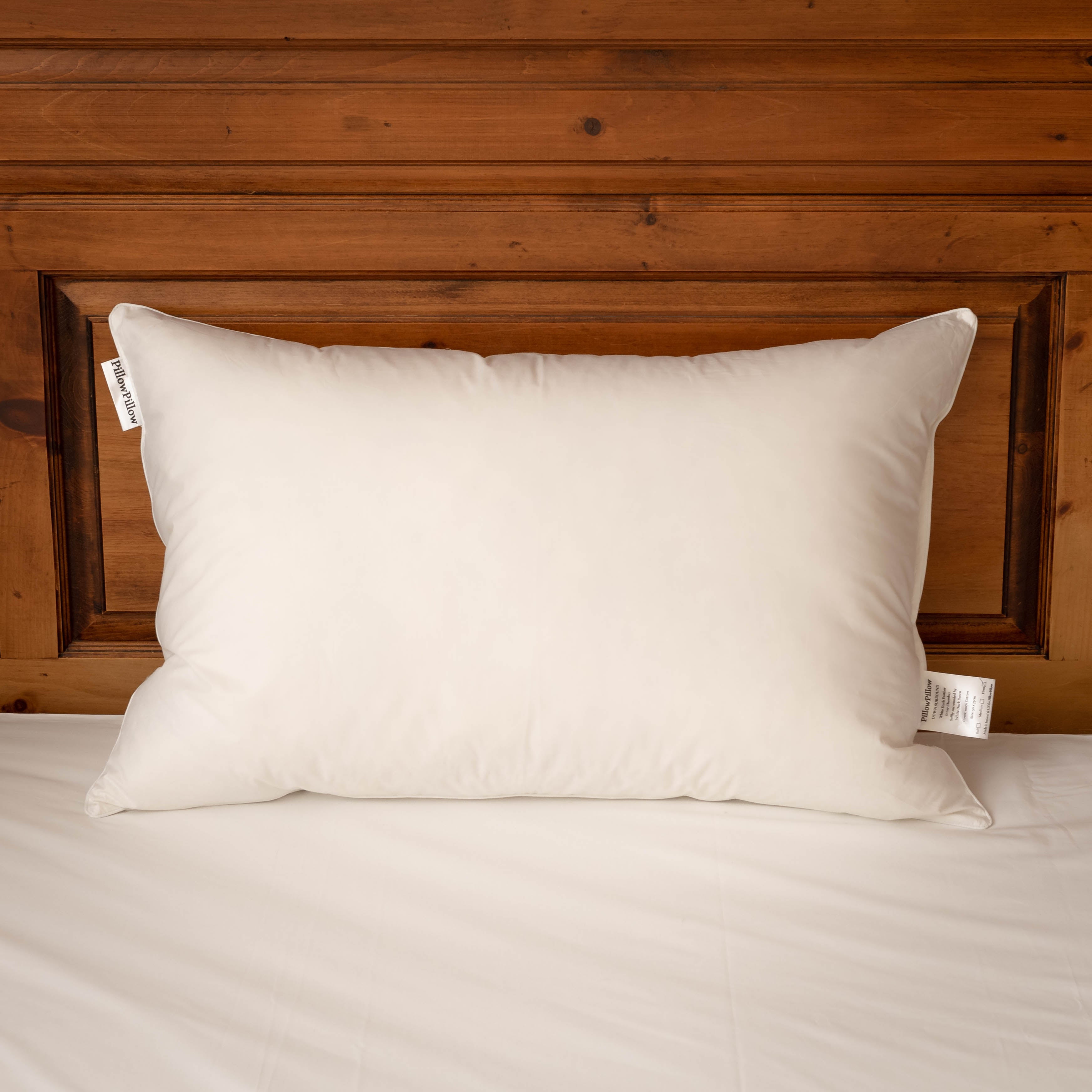 Down Surround pillow on a bed with oak headboard