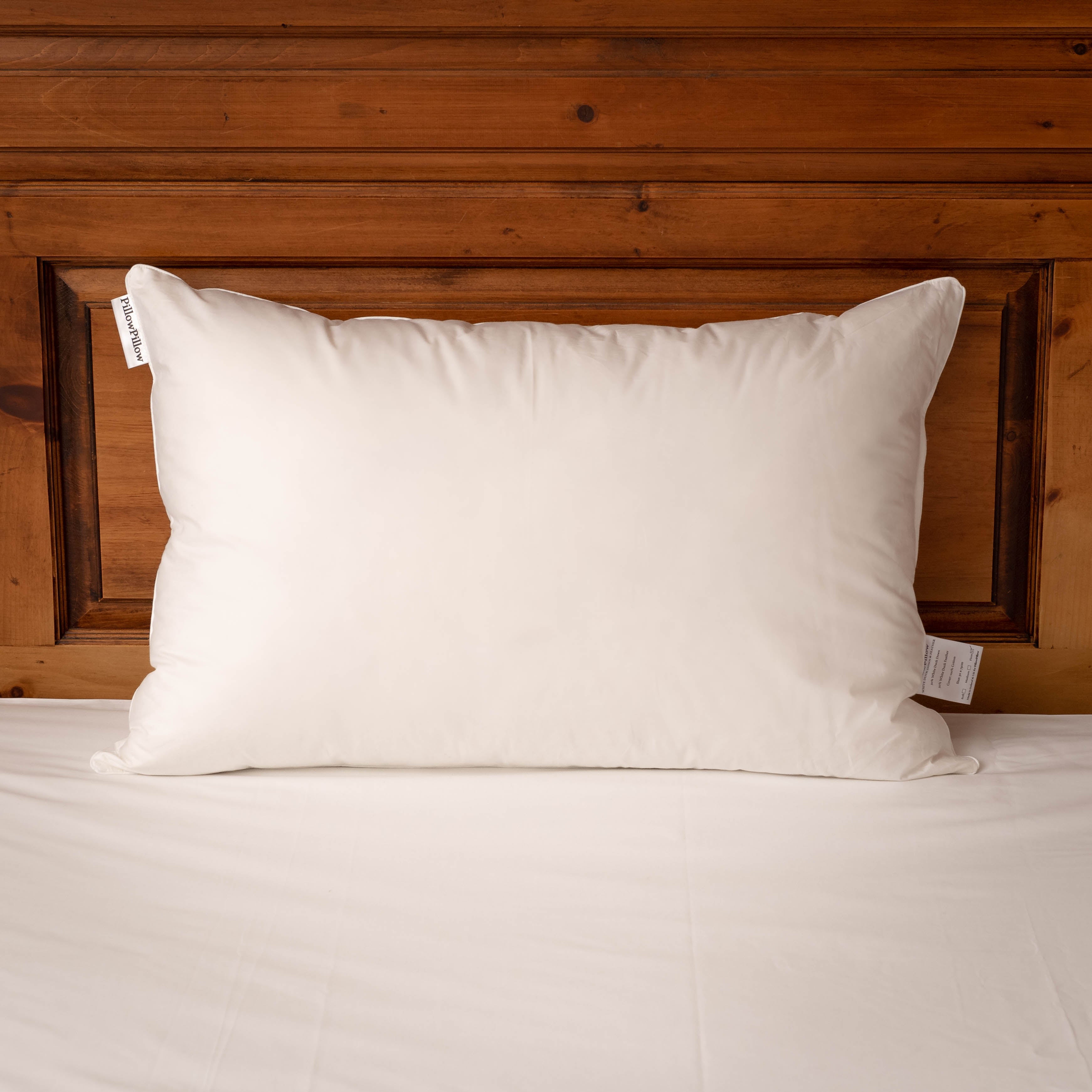White Duck Down and feather Pillow on a bed with a timber headboard