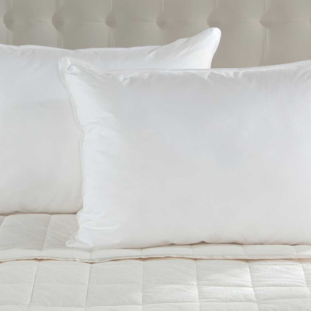 Pair of White Duck Down Pillows on a bed with padded headboard